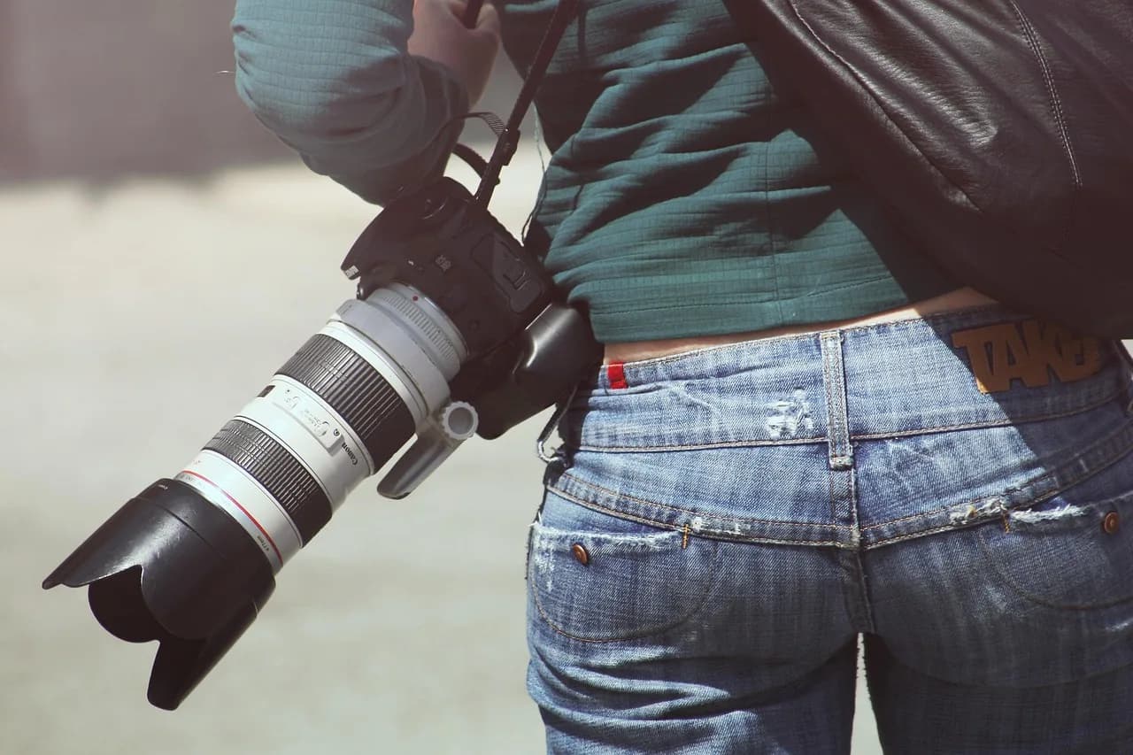 Eva Schloss — woman, photographer, camera, digital camera, dslr, slr, behind, bottom, back, canon, girl, lens, photography, camera lens, equipment, professional, jeans, casual