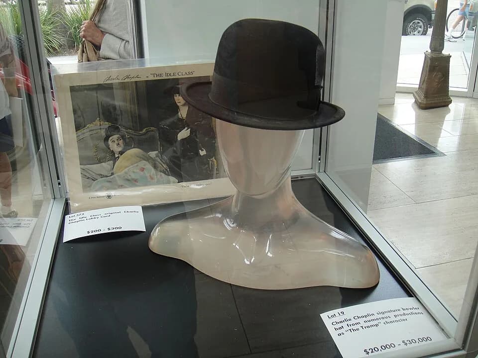 Charlie Chaplin - Charlie Chaplin signature bowler hat as "The Tramp" character and original "The Idle Class" lobby card at the Debbie Reynolds Auction Breaks Up Historic Hollywood Collection (The Pal