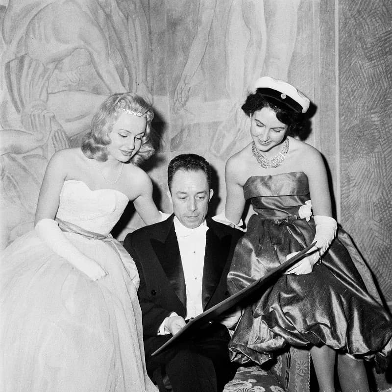 Albert Camus - Stockholms Stadshus. Nobelpristagaren i litteratur Albert Camus i samtal med två unga kvinnor på Nobelfesten, möjligen framför Törnemans freskomålning.