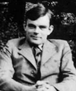 Alan Turing - Alan Turing sitting in a chair.