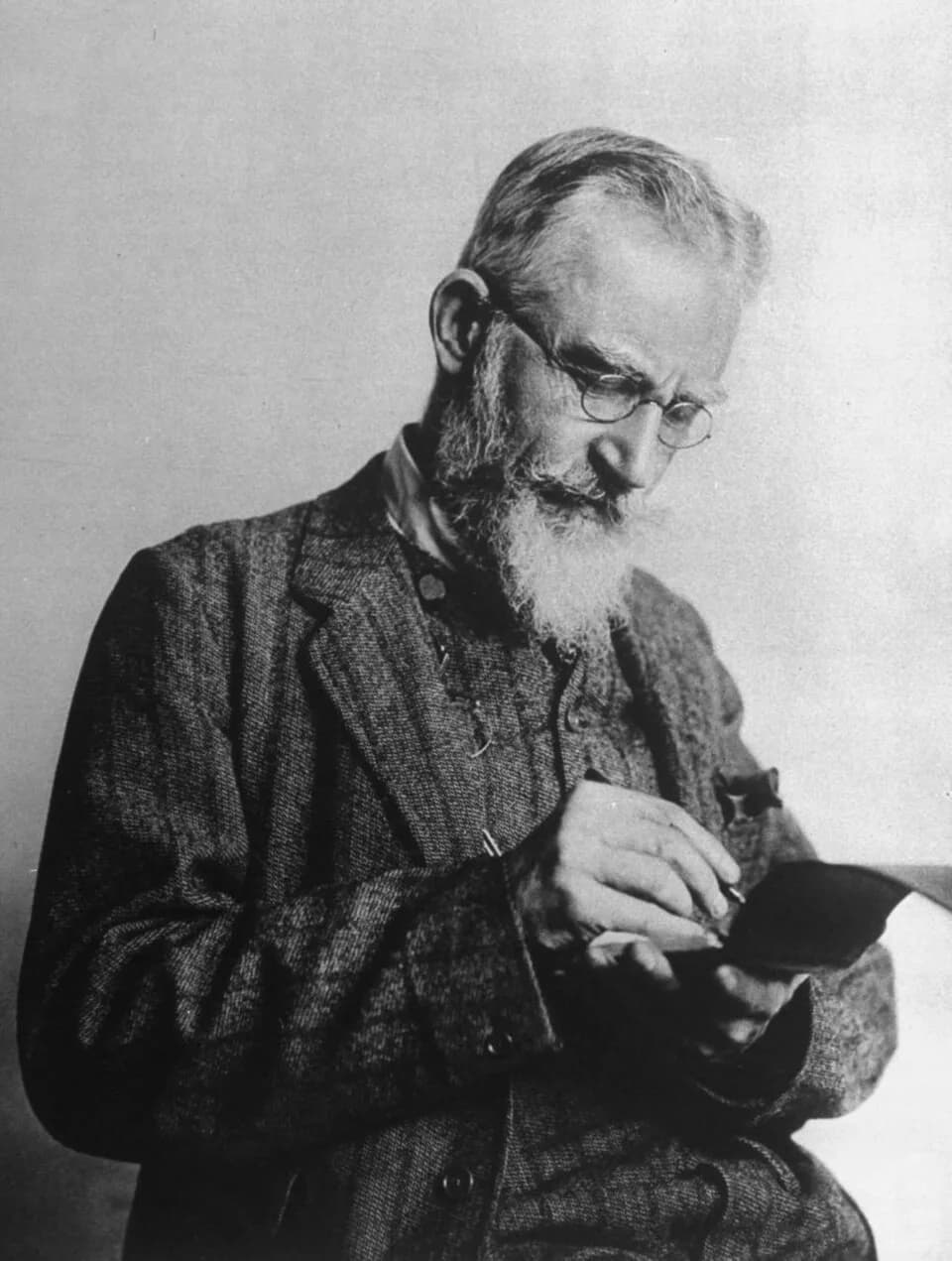 George Bernard Shaw - Anglo-Irish playwright George Bernard Shaw writing in notebook at time of first production of his play "Pygmalion."