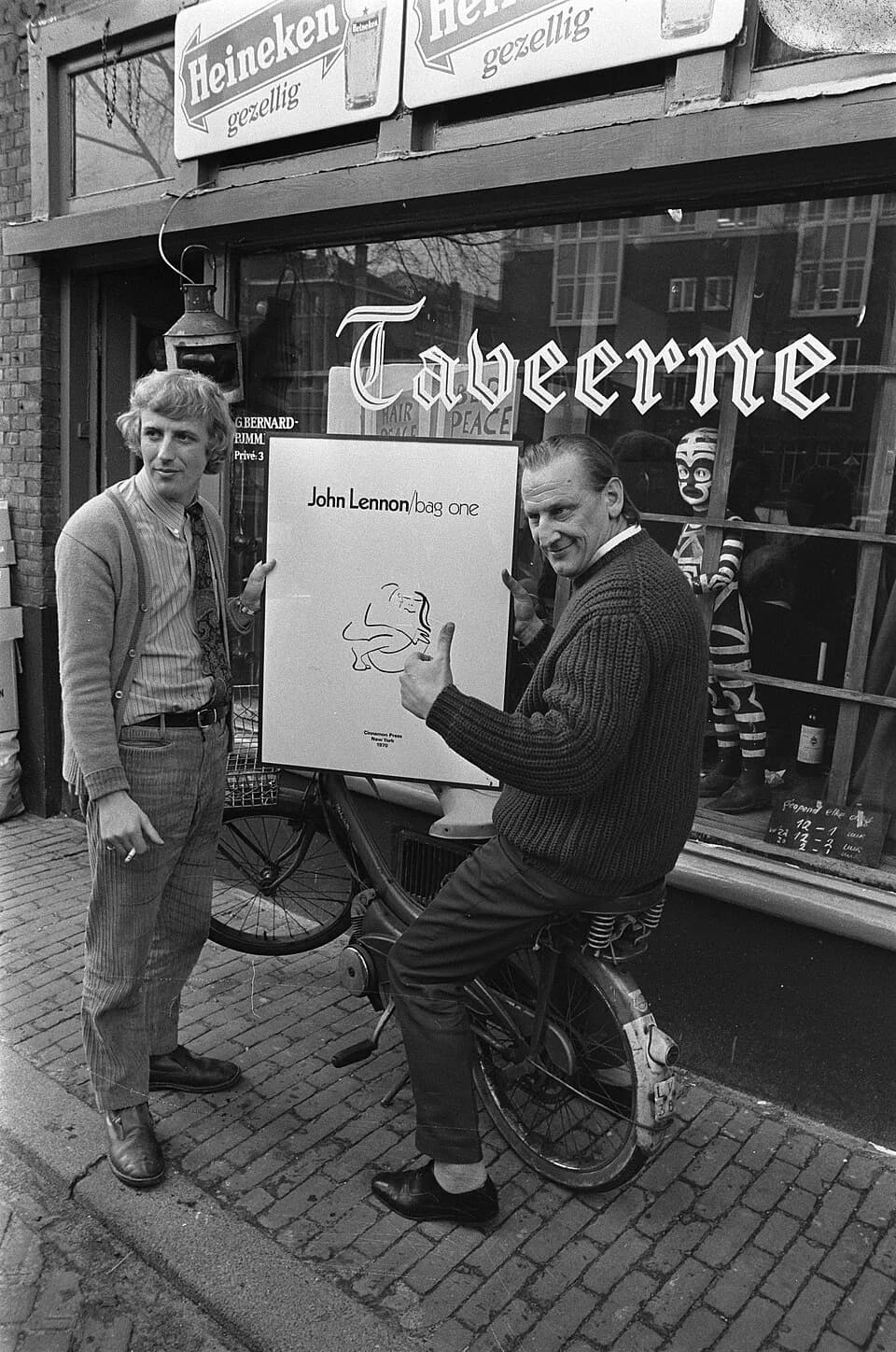 John Lennon - Collectie / Archief : Fotocollectie Anefo
Reportage / Serie : [ onbekend ]
Beschrijving : Expositie van litho's van John Lennon in galeries P96 en Podulke, Amsterdam. Links G. Bernard en