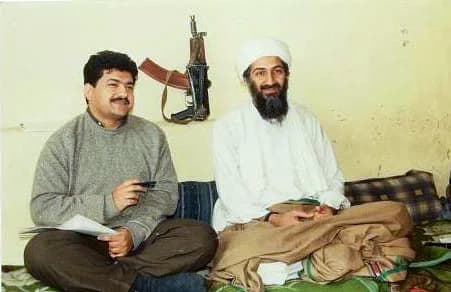 Osama bin Laden - Pakistani journalist Hamid Mir interviewing Osama bin Laden, circa March 1997 – May 1998. Behind them on the wall is an AKS-74U carbine.