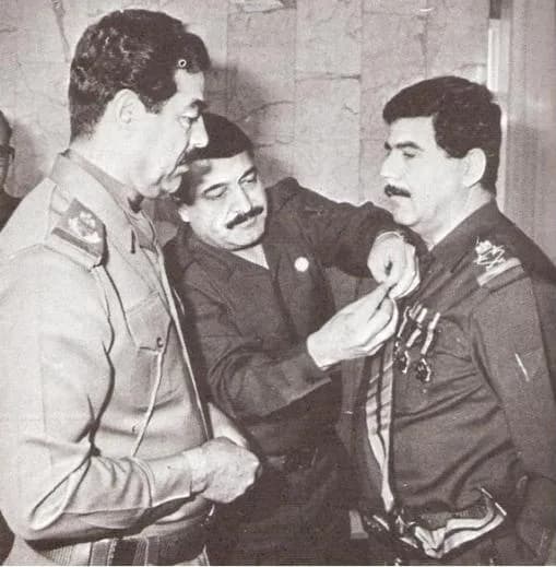 Saddam Hussein - Adnan Khairallah, Iraqi Defence Minister, being awarded by Saddam Hussein