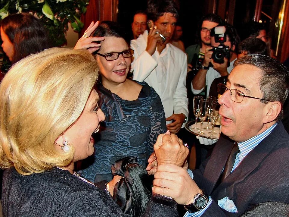 Hebe Camargo - Jornalista brasileiro Paulo Henrique Amorim à direita juntamente com a apresentadora de TV brasileira Hebe Camargo. Ao fundo, também pode ser visto o ator e apresentador Márcio Garcia.