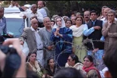 Benazir Bhutto - Former Prime Minister of Pakistan, Benazir Bhutto (center), speaks to supporters outside her house.