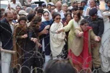 Benazir Bhutto - Former Prime Minister of Pakistan, Benazir Bhutto (center), with supporters outside her house.