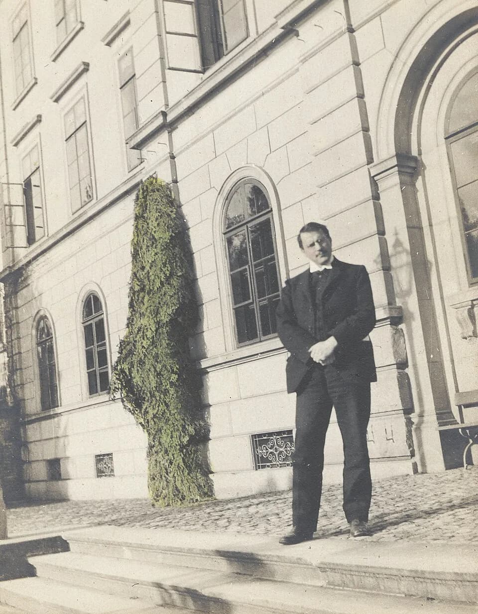 Carl Jung - Hand-colored photograph of Carl Jung in USA, published in 1910. Carl Gustav Jung, full-length portrait, standing in front of building in Burghölzi, Zurich