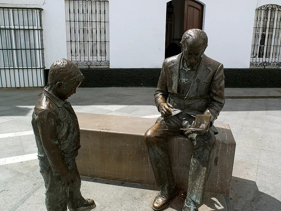 José Saramago - Estatua de José Saramago en Conil de la Frontera, leyendo un libro a un niño, realizada por el escultor Augusto Arana.