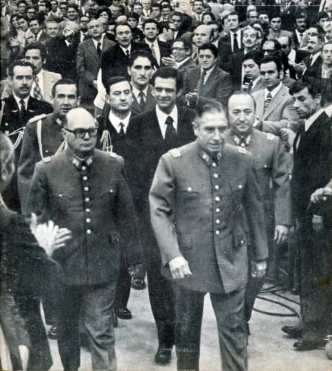 Augusto Pinochet - Los Generales Augusto Pinochet Ugarte, César Raúl Benavides, seguidos por Sergio Fernández en un acto en el Edificio Diego Portales en el 1º de mayo de 1976.