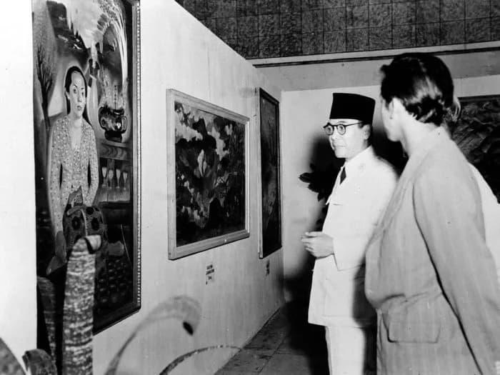 Sukarno Sukarno - President Soekarno visiting a paintings exhibition, looking at 'Sumilah' by Sudibjo