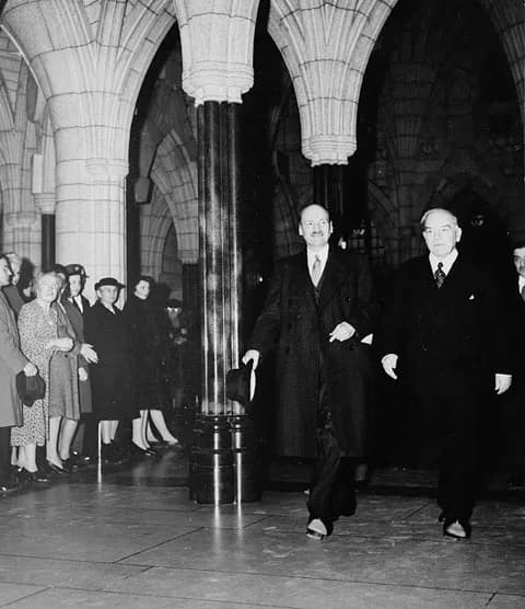 Clement Attlee - Rt. Hon. Clement Attlee of Great Britain, walks with Rt. Hon. W.L. Mackenzie King through the columned corridors of the Centre Block, Parliament Buildings on his way to address a join