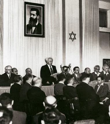 Theodor Herzl - David Ben-Gurion (First Prime Minister of Israel) publicly pronouncing the Declaration of the State of Israel, May 14 1948, Tel Aviv, Israel, beneath a large portrait of Theodor Herzl,