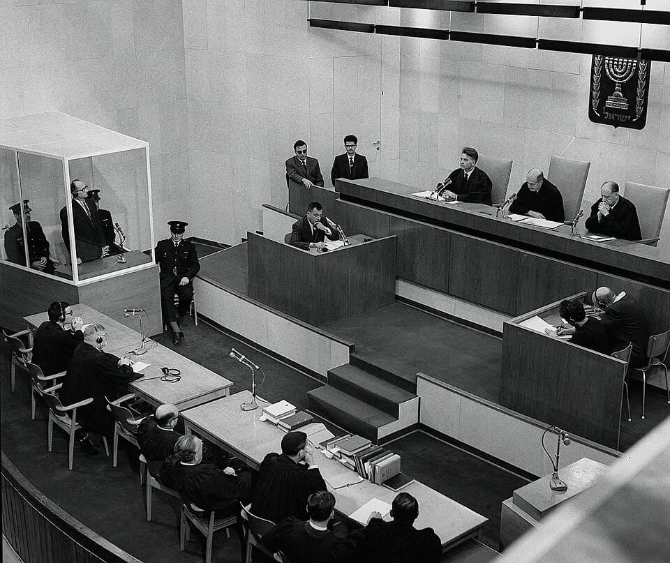 Adolf Eichmann - Defendant Adolf Eichmann (inside glass booth) is sentenced to death by the court at the conclusion of the Eichmann Trial. At the left table seated with two persons, the person on the 