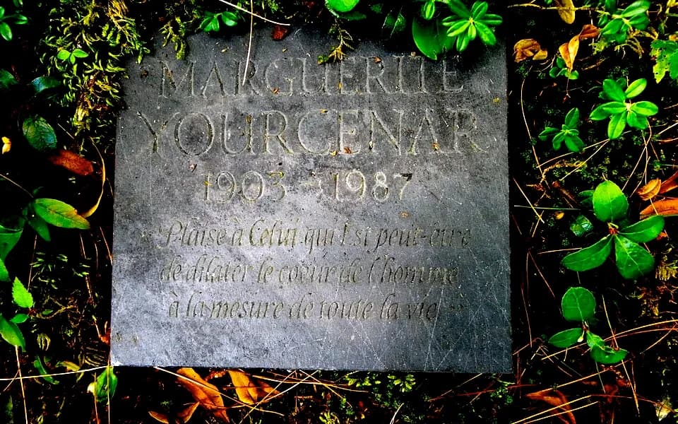 Marguerite Yourcenar - Marguerite Yourcenar's funeral stone. It is very small, mesuring less than 5"x5". Her epitaph, in French, reads, "Plaise à Celui qui Est peut-être de dilater le coeur de l'homme