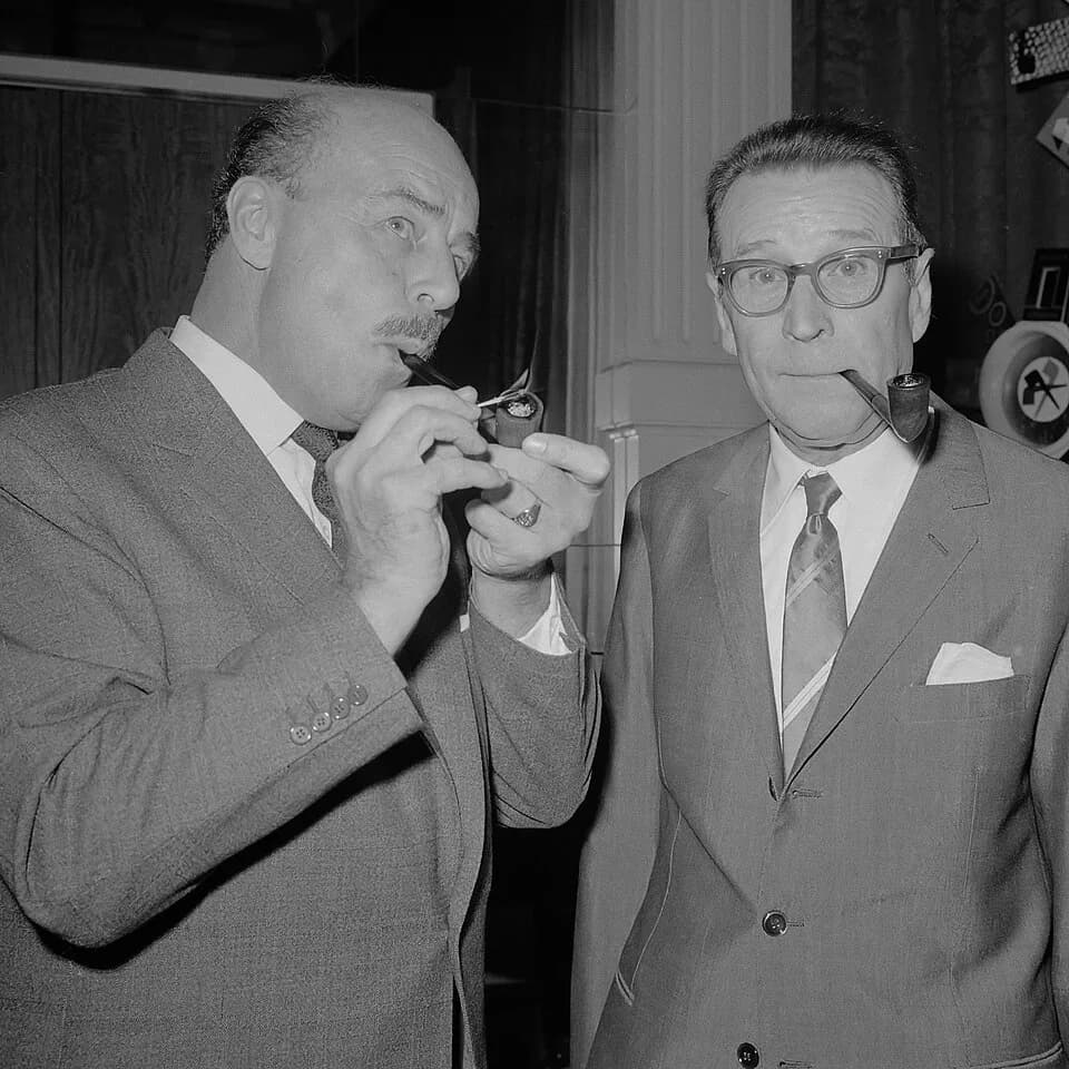 Georges Simenon - Georges Simenon samen met de acteur Jan Teulings (links) bij het beeldje van Maigret in het Amstelhotel
2 september 1966