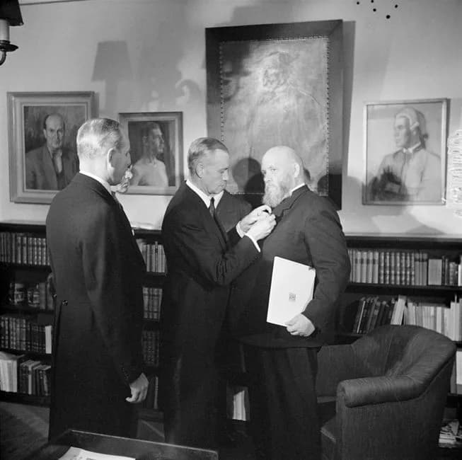 Frans Eemil Sillanpää - Chief executive officer Heikki Reenpää attaches the publishing house Otava's badge for merit, the Agricola medal, on Sillanpää's lapel. Otava had ”redeemed” the author from WSO