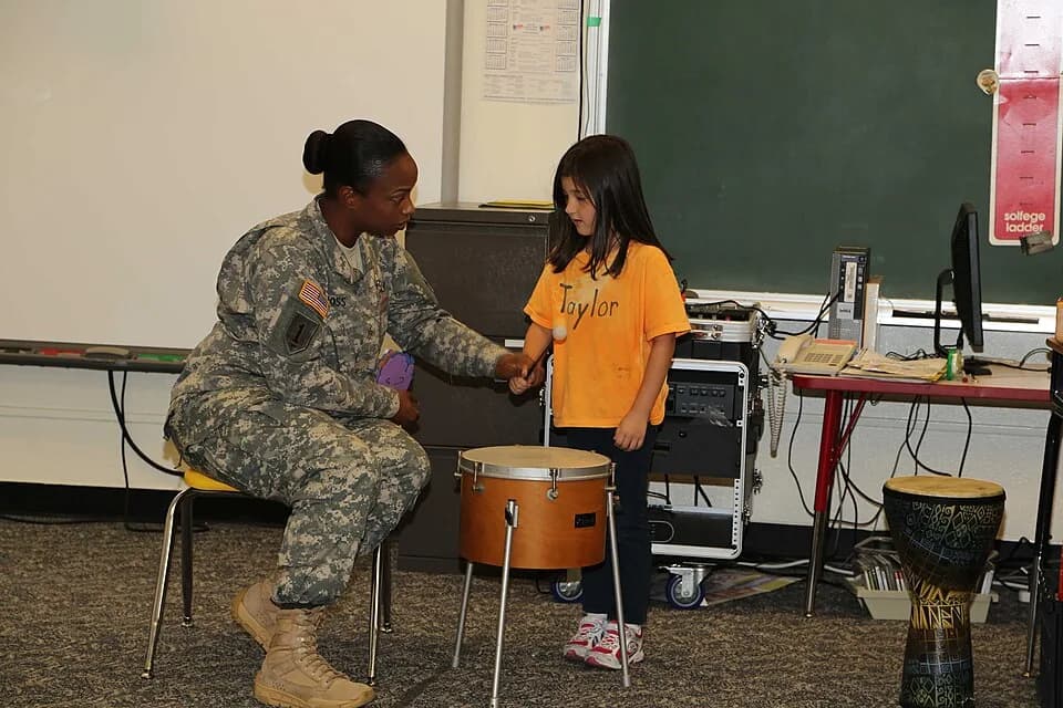 Bob Hope - U.S. Army Sgt. Jamara Ross, left, assigned to the 10th Regional Support Group, Support Operations and Maintenance, works with a kindergarten student in the Bob Hope Primary School, during a