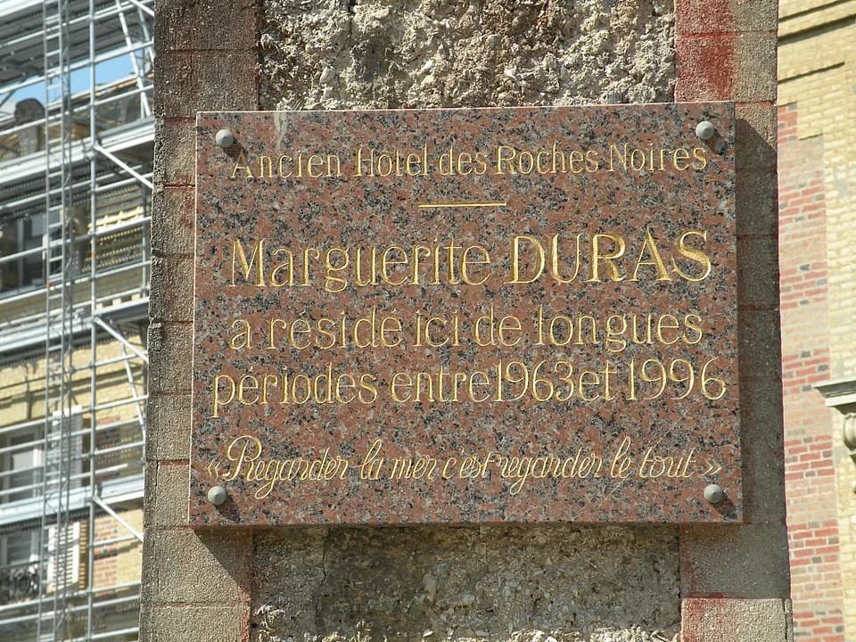 Marguerite Duras - Plaque rendant hommage à Marguerite Duras sur l'hôtel des Roches Noires à Trouville-sur-Mer ; elle y a résidé entre 1963 et 1996.