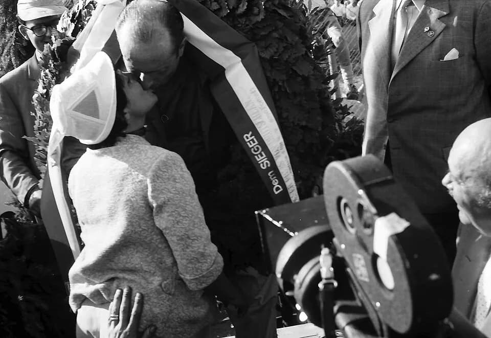 Juan Manuel Fangio - Race winner Juan Manuel Fangio is congratulated by his partner, Andrea Berruet, on the podium following the 1957 German Grand Prix, at the Nürburgring, West Germany.