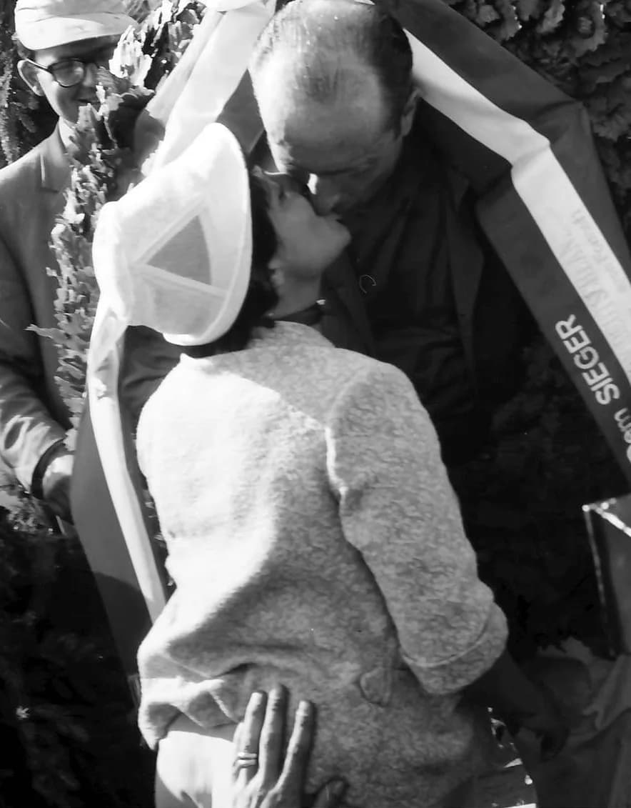 Juan Manuel Fangio - Race winner Juan Manuel Fangio is congratulated by his partner, Andrea Berruet, on the podium following the 1957 German Grand Prix, at the Nürburgring, West Germany.