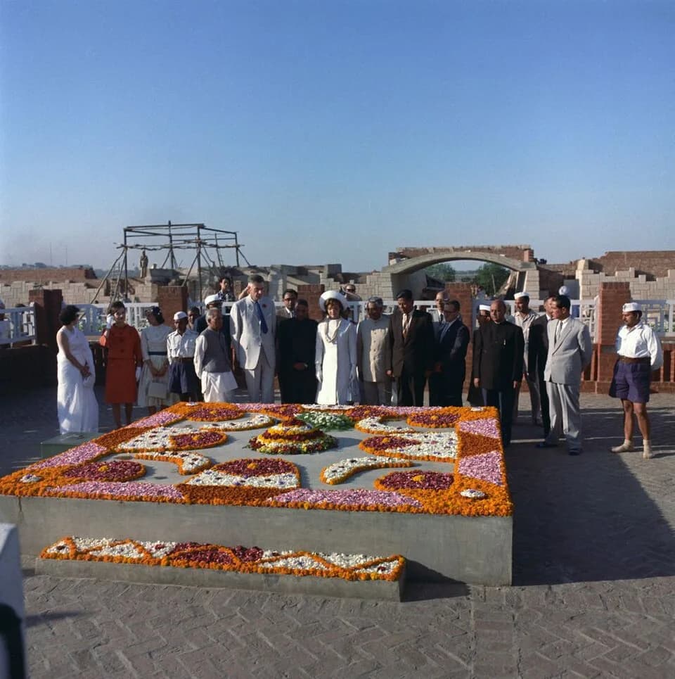 John Kenneth Galbraith - First Lady Jacqueline Kennedy (center) observes a minute of silence after laying a sheaf of roses on the Samadhi of Mohandas Gandhi, “Raj Ghat,” in Delhi, India. Chief Commiss