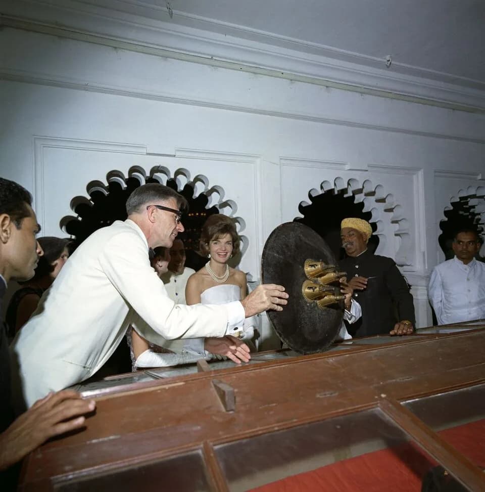 John Kenneth Galbraith - First Lady Jacqueline Kennedy looks at objects from the medieval armory of the Maharana of Udaipur, Bhagwat Singh, at a reception at Fateh Prakash Palace in Udaipur, Rajasthan