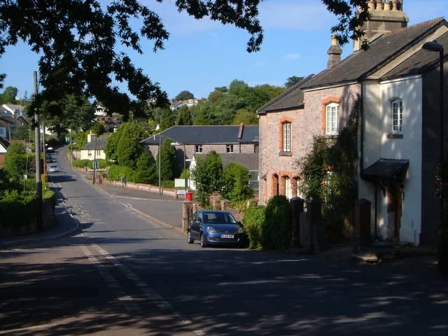 Robert Graves - Galmpton. A view down Greenway Road from the shady junction with Old Road by the school. The beige-coloured farmhouse (Vale House) visible at the bottom of the hill was occupied by Rob