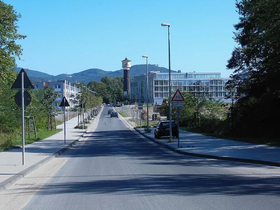 Joseph Schumpeter - Street Joseph-Schumpeter-Allee in Bonn-Ramersdorf. In the background the Siebengebirge mountains can be seen, on the right buildings of the former Cement works.