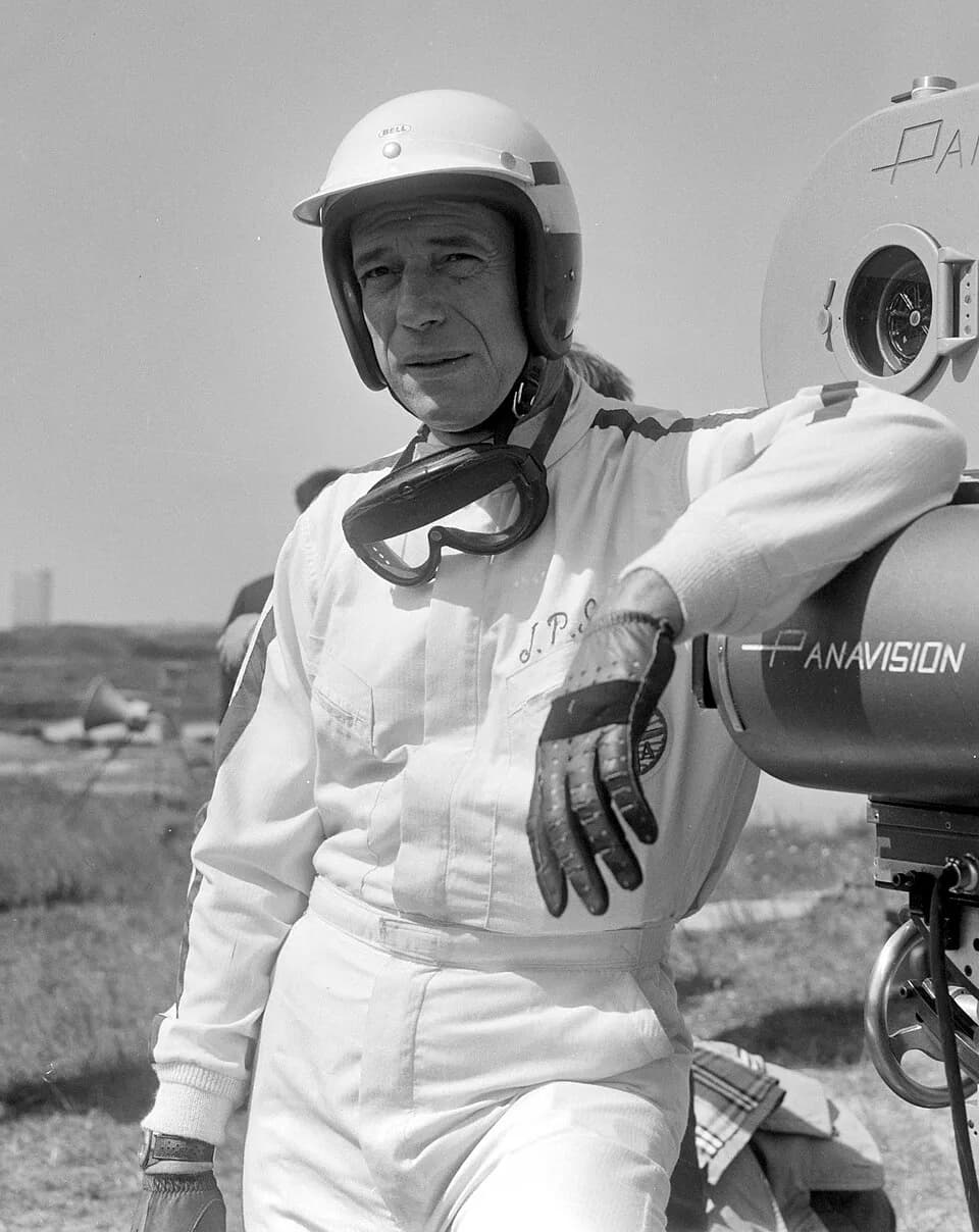 Yves Montand - Cineramafilm "Grand Prix", filmopnames te Zandvoort, Yves Montand [als coureur Jean Paul Sarti] bij de filmcamera