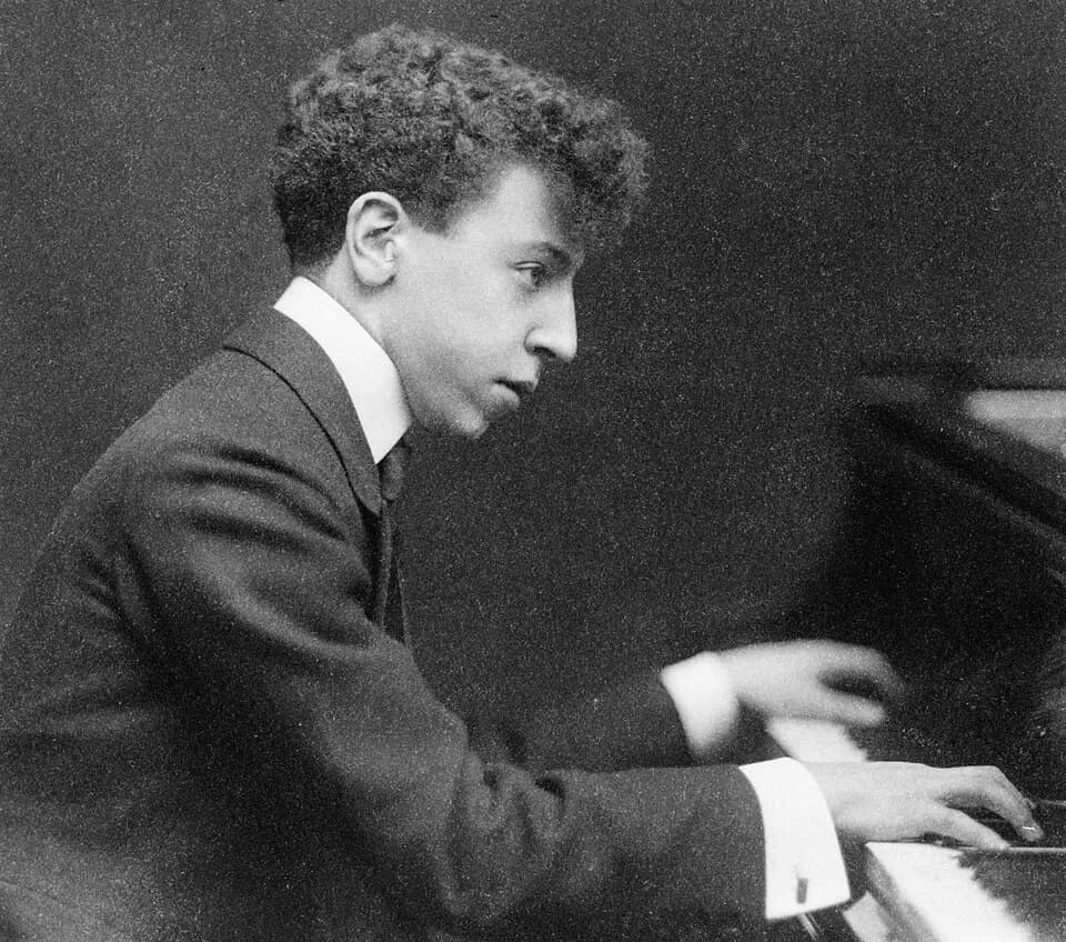 Arthur Rubinstein - Arthur Rubinstein, half-length portrait, seated at piano, facing right.