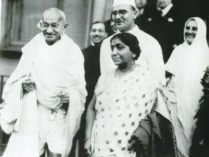 Sarojini Naidu - Gandhi in London with Sarojini Naidu at his side, Mahadev Desai behind her, and Mirabehn (Madeleine Slade) to the right.