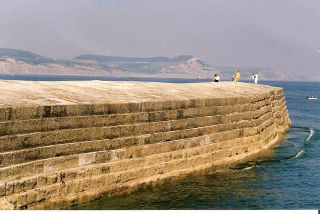 John Fowles - The High Wall on the Cobb, Lyme Regis The people stood to the right on the top of the High Wall, are in roughly the same position as Meryl Streep stood in the film "The French Lieutenant