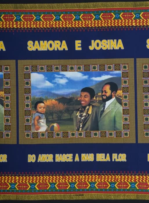 Samora Moisés Machel - Op deze kapulana staat in drievoud een voorstelling van het gezin van Samora Machel. Machel was leider van de FRELIMO, sinds de dood van Eduardo Mondlane (1969), en werd in 1975