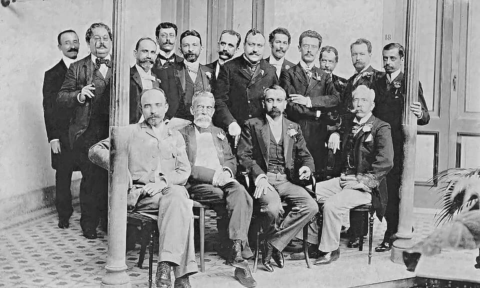 Machado de Assis - Foto dos integrantes da “panelinha”, criada em 1901 para a realização de festivos ágapes e encontros de escritores e artistas. A fotografia é de um almoço no Hotel Rio Branco (1901)