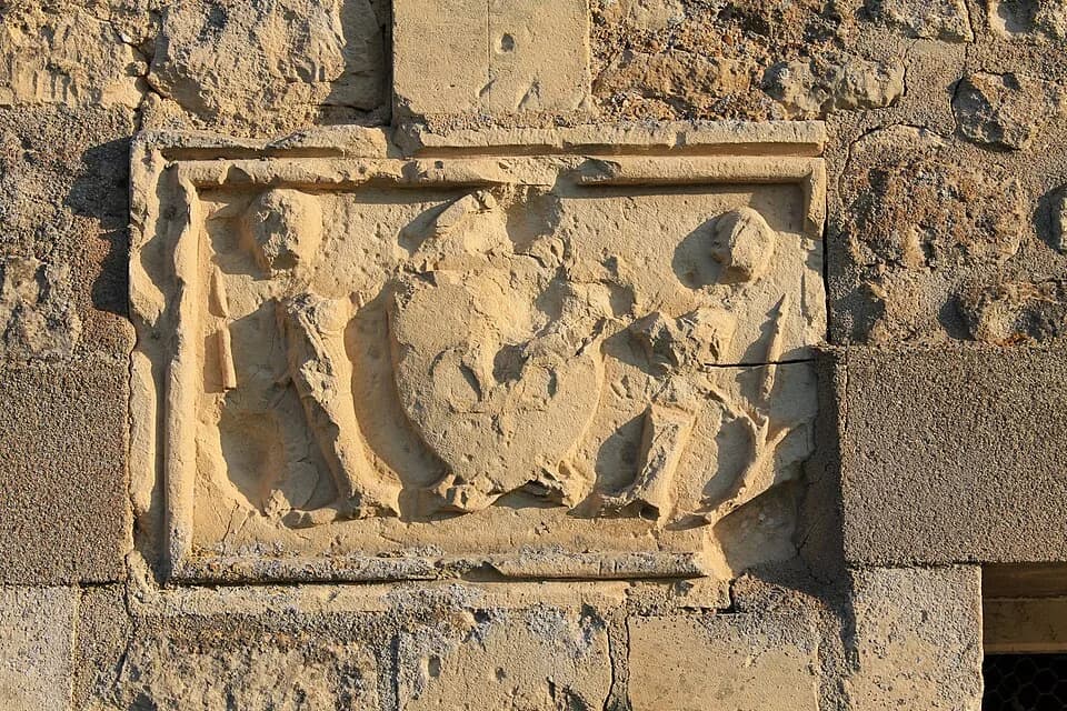 Henry I of France - Bas-relief représentant deux chevaliers et un blason commémorant le passage de l'Orne au gué d'Athis et le massacre par Guillaume-le-Conquérant des barons normands conjurés vaincus