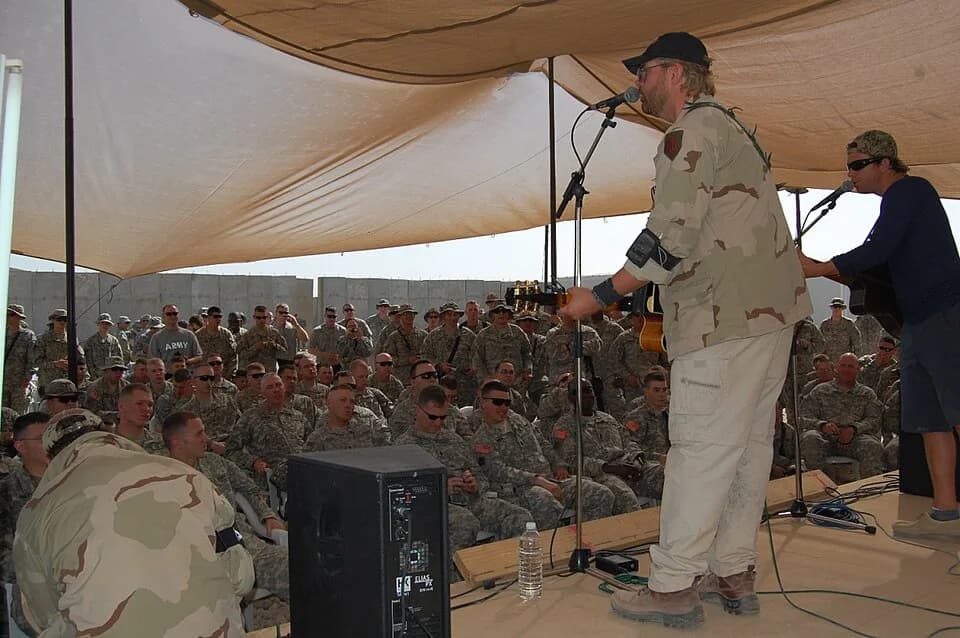 Toby Keith - Toby Keith (left) and Scott Emmerick play an acoustic set for the Soldiers of 1-15th Infantry Regiment at Combat Outpost Carver, Salman Pak, Iraq, April 26. Keith included the outpost, on