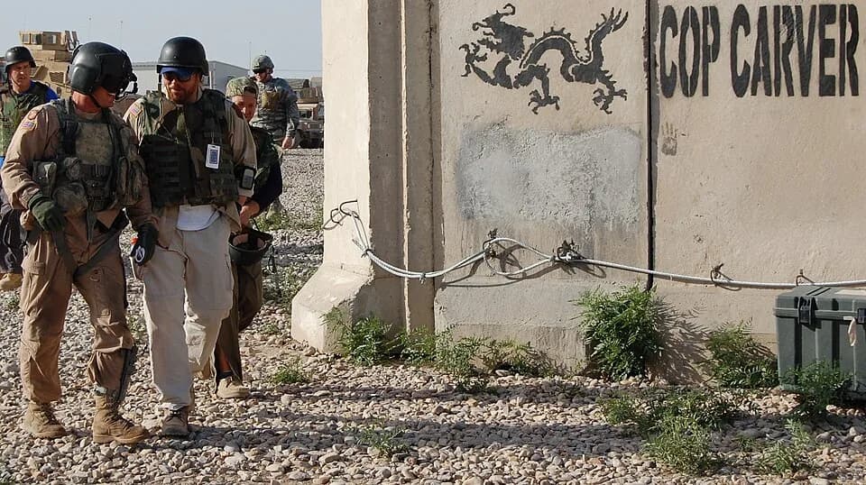 Toby Keith - Toby Keith walks toward the landing zone with a UH-60 Black Hawk crew chief from the 3rd Combat Aviation Brigade, 3rd Infantry Division, after playing for Soldiers at Combat Outpost Carve