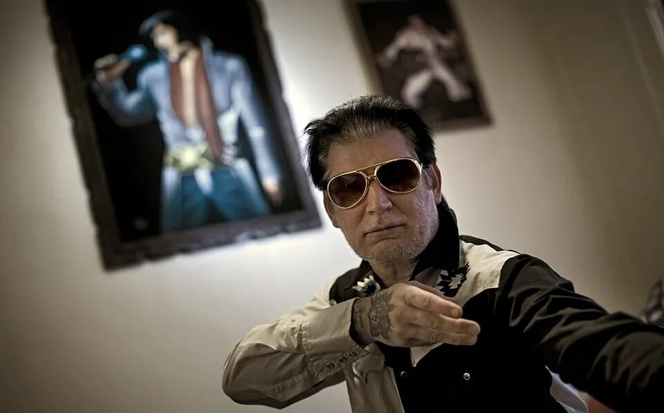 Elvis Presley - Jesco White with velvet paintings of Elvis Presley in background.
