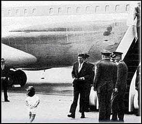 John F. Kennedy - John F. Kennedy disembarks from a plane, while a girl, probably Caroline, runs towards him.