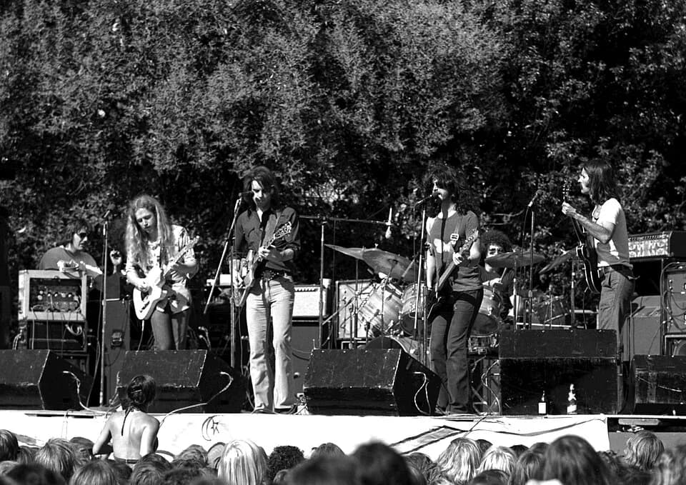 Bob Weir - The band Kingfish performing in El Camino Park, Palo Alto CA, June 8, 1975. 
Left to right: Barry Flast (keyboards), Robbie Hoddinott (guitar), Bob Weir (guitar), Dave Torbert (bass), Chris