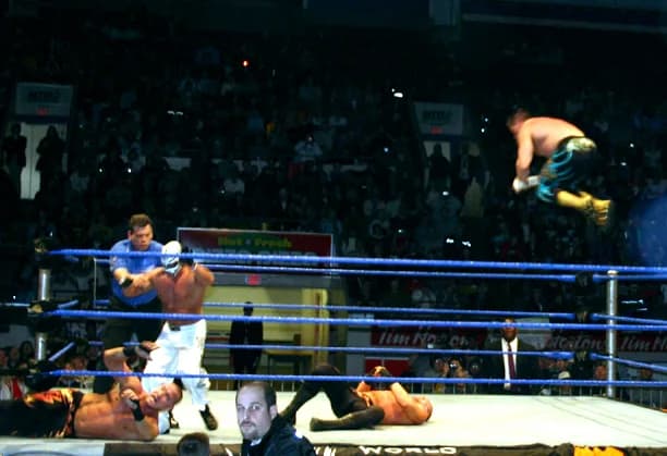 Eddie Guerrero - Eddie Guerrero gives a Frog Splash during his tag team match with Rey Mysterio against the Basham Brothers during a WWE house show held in Kitchener, Ontario, Canada on January 15, 20