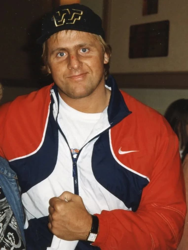 Owen Hart - Pro wrestler Owen Hart posing with a fan (cropped)