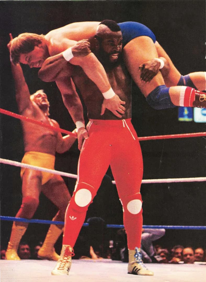 Roddy Piper - Mr T. hoists "Rowdy" Roddy Piper up onto his shoulders as Hulk Hogan cheers in the background during the main event of Wrestlemania, March 1985
