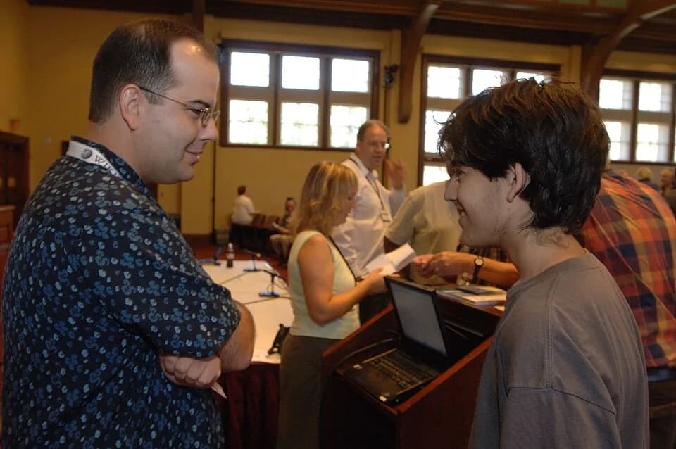Aaron Swartz - Interim Executive Director Brad Patrick talking with Aaron Swartz at Wikimania 2006. Board Chair Florence Devouard in background.