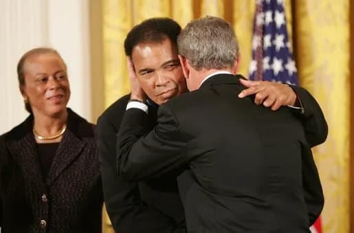 Muhammad Ali - As Mrs. Lonnie Ali looks on, President George W. Bush embraces three-time heavyweight boxing champion of the world Muhammad Ali after presenting him with the Presidential Medal of Freed