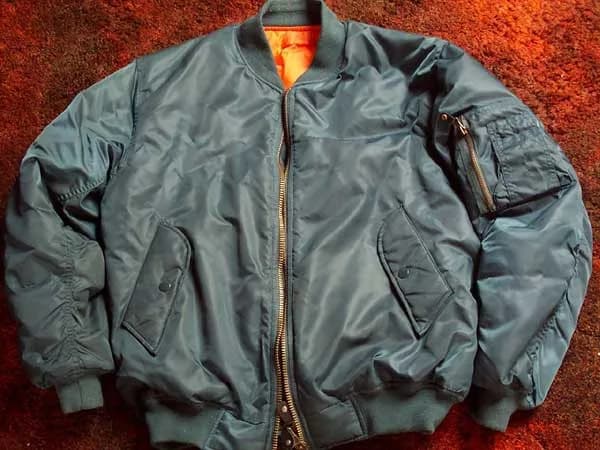 Steve McQueen - A modern nylon MA-1 bomber jacket in petrol color with orange lining.