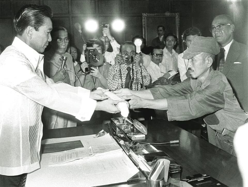 Hiroo Onoda - Japanese imperial army soldier Hiroo Onoda (R) offering his military sword to Philippine President Ferdinand E. Marcos (L) on the day of his surrender, March 11, 1974.