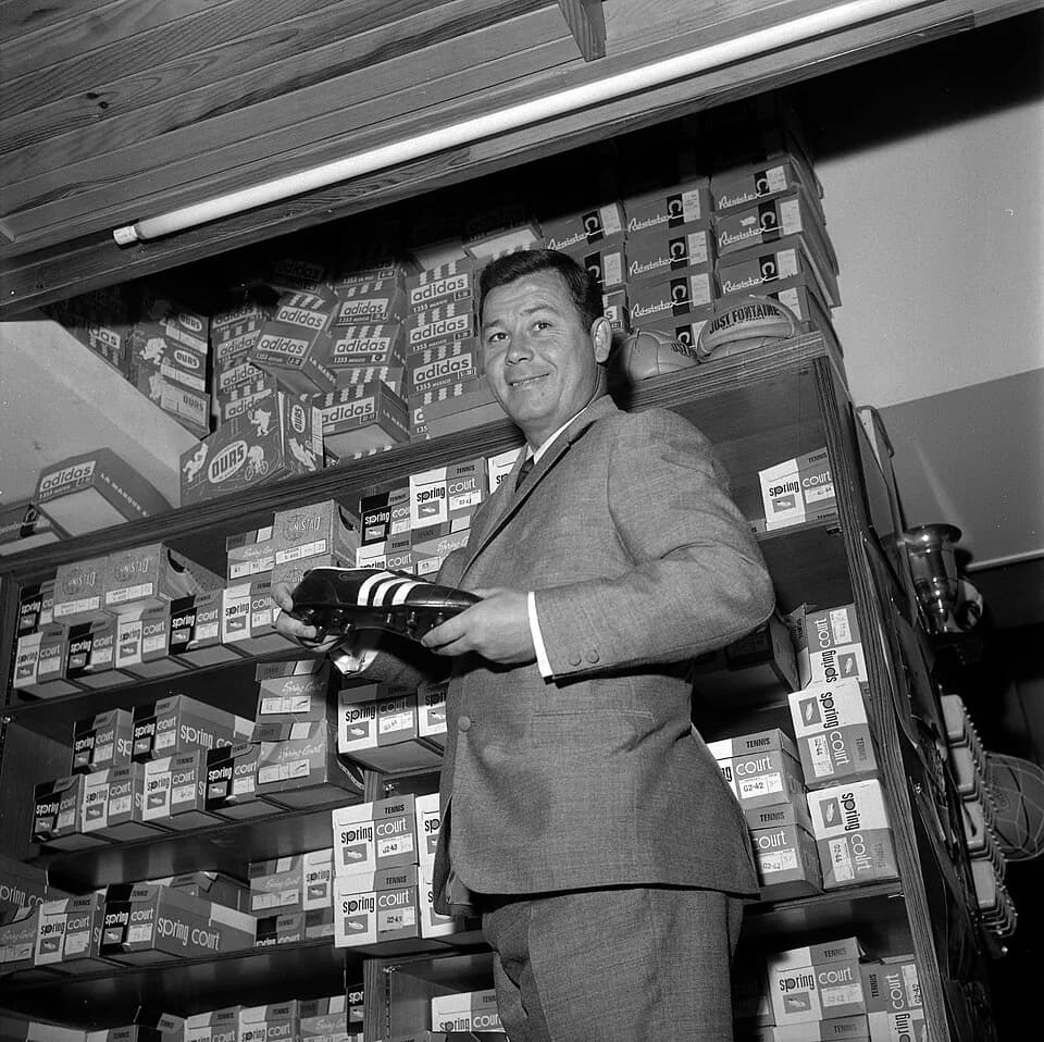 Just Fontaine - Magasin "Justo Sport", 26 rue Saint-Antoine-du-T. 23 mai 1966. Just Fontaine (footballeur) dans son magasin.  Plan taille du joueur tenant une chaussure à crampon dans ses mains (contr