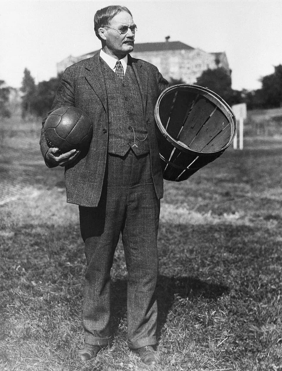 James Naismith - James Naismith with a soccer ball and a basket.